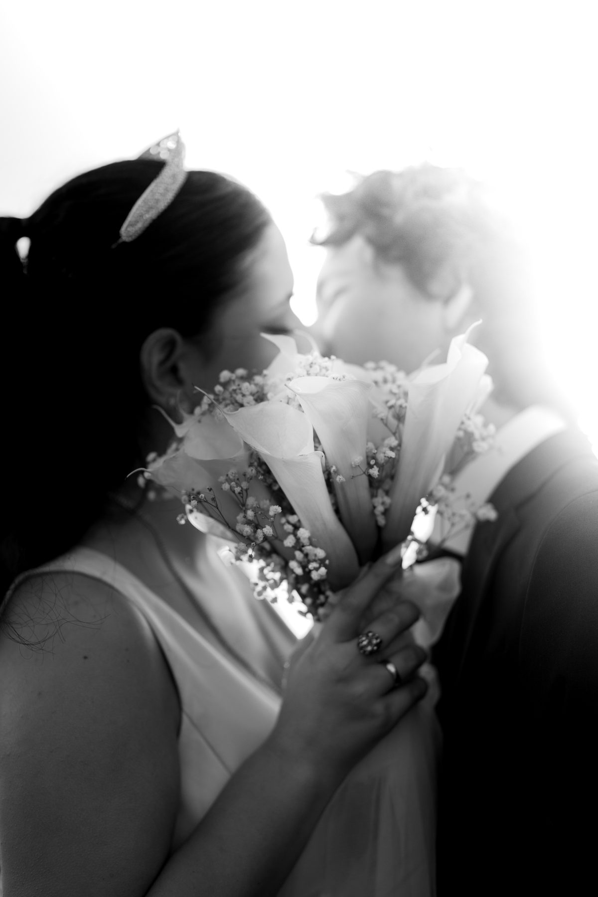 Black and white: a bride with her bouquet, a kiss