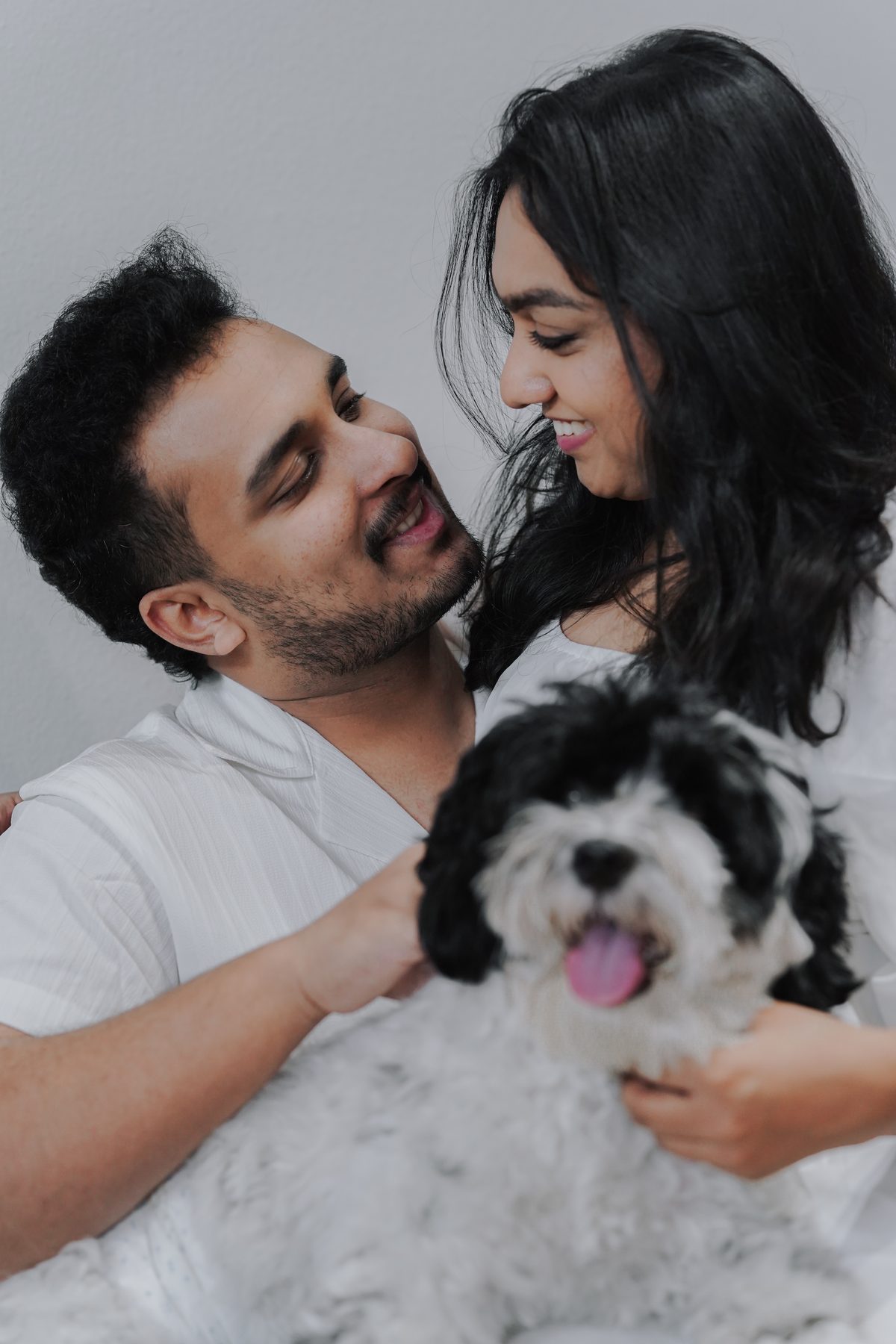 A couple laughing with their small dog